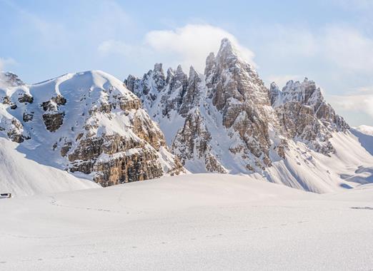 Deeply snow-covered winter landscape with a striking mountain range in the Three Peaks region.