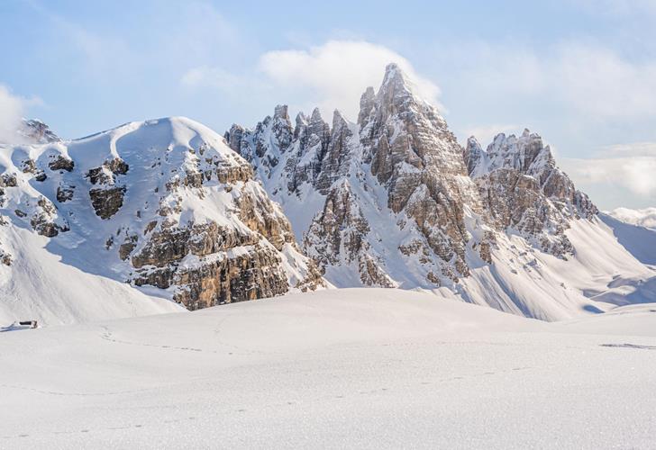 Tief verschneite Winterlandschaft mit markantem Gebirge in der Drei Zinnen Region