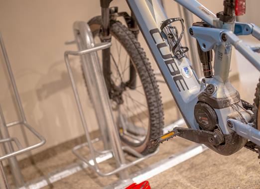 Deposito bici con diverse biciclette parcheggiate nelle rastrelliere.