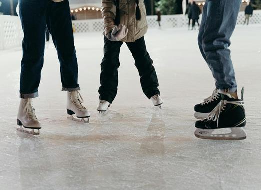 Ice skater on an ice rink in a winter mountain landscape.