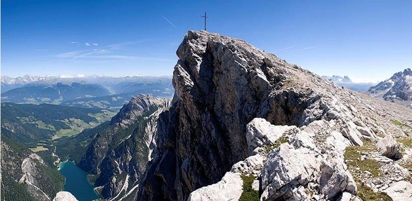 Rocky Seekofel with a summit cross and views of the surrounding alpine mountain landscape.