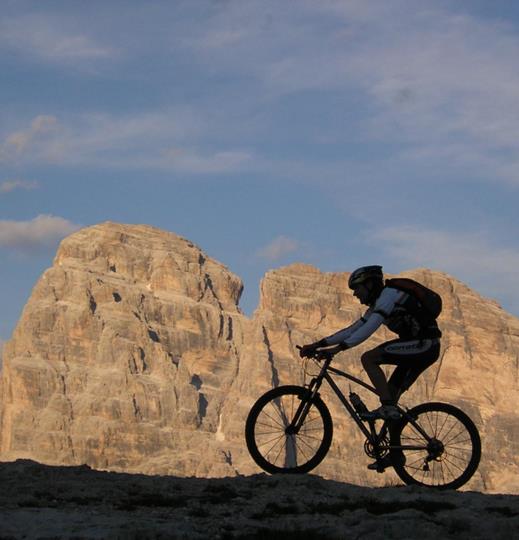 Cyclists on rocky terrain with the Three Peaks in the background.