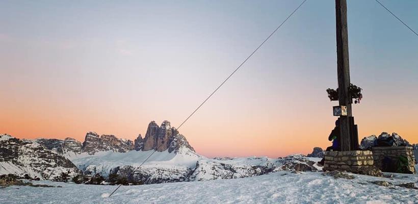 Gipfelkreuz am Strudelkopf im Winter mit schneebedGipfelkreuz am Strudelkopf bei Sonnenuntergang im Winter mit schneebedeckten Bergen im Hintergrund.eckten Bergen im Hintergrund beim Sonnenuntergang.
