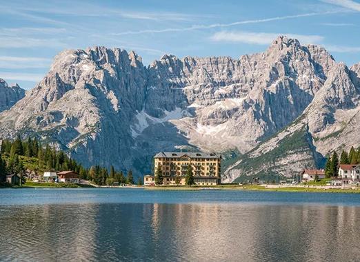Lake Misurina with a historic building and striking mountains in the background.