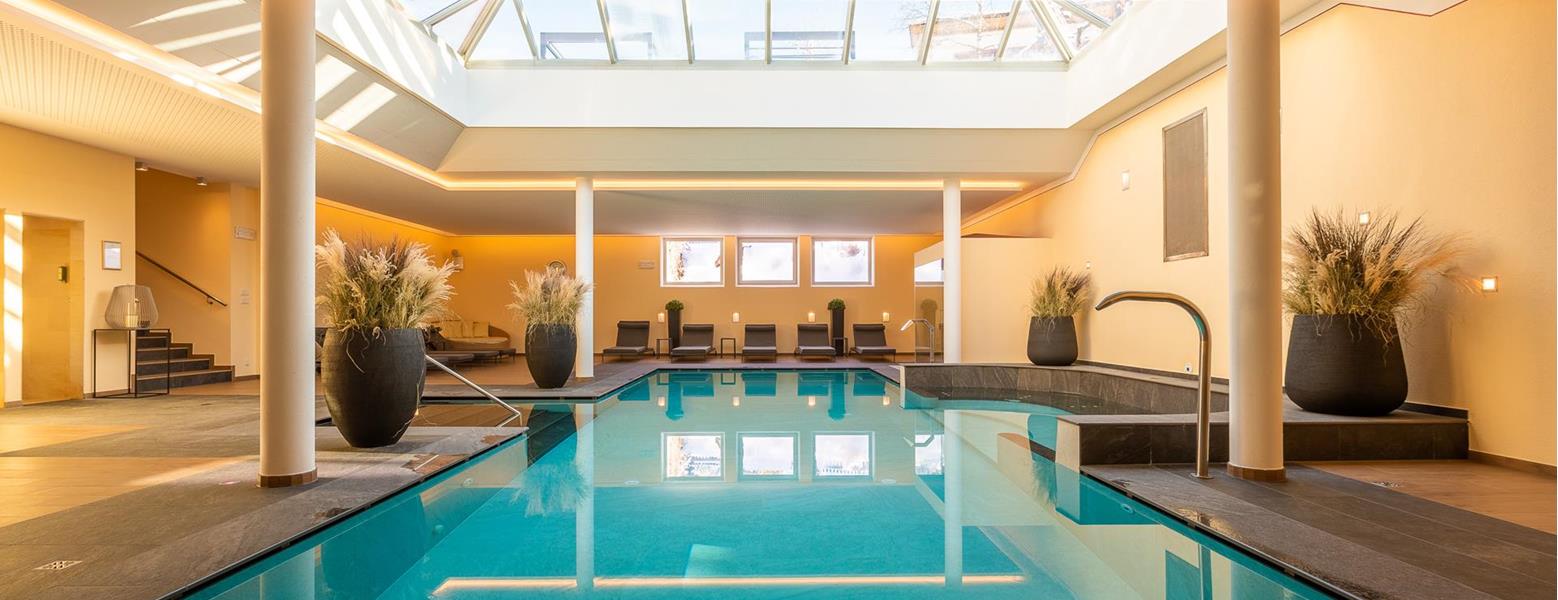 Innenpool der Villa Stefanie mit Sonnenliegen und großem Dachfenster.