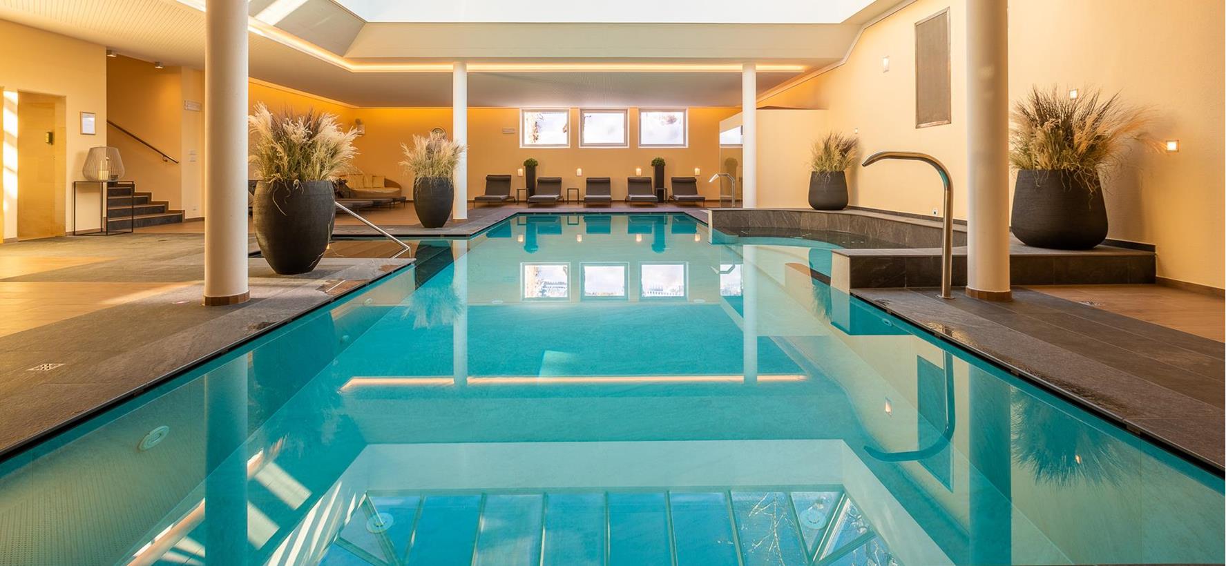 Innenpool der Villa Stefanie mit Sonnenliegen und großem Dachfenster.