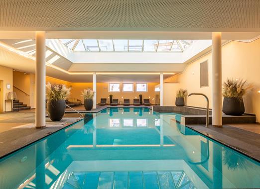 Indoor pool of Villa Stefania with sun loungers and a large skylight.