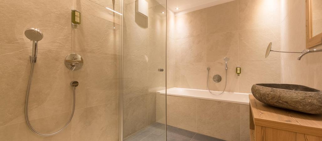 Suite Natura bathroom with washbasin, shower and bathtub.