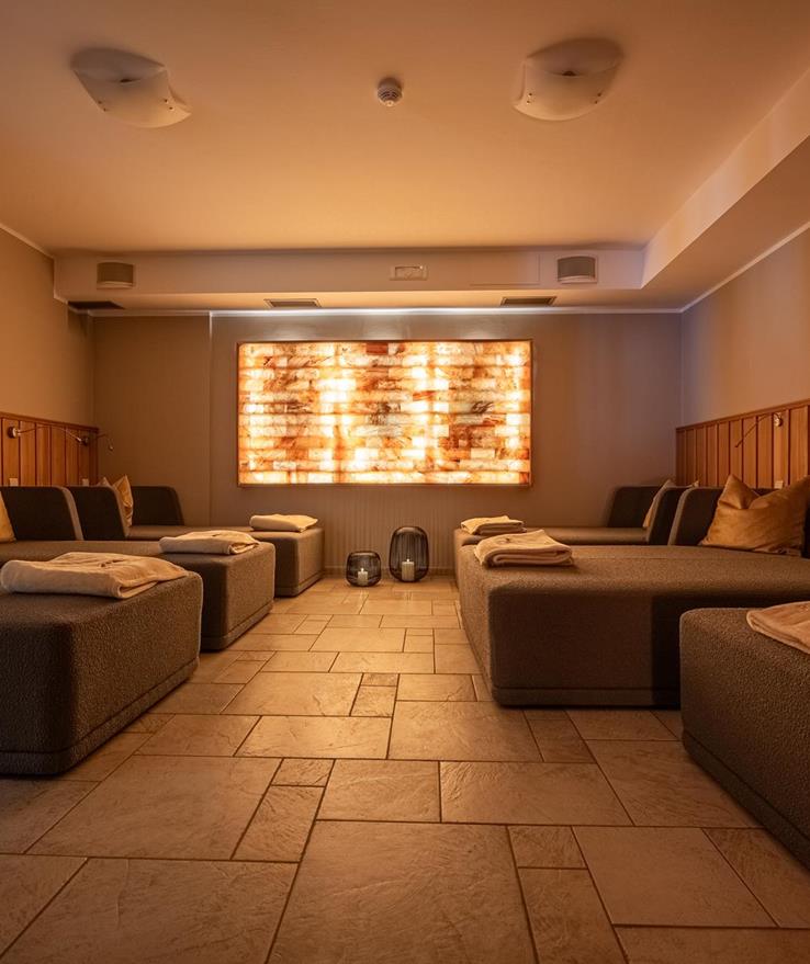 Sala relax nell’area wellness con grandi letti e luce soffusa.