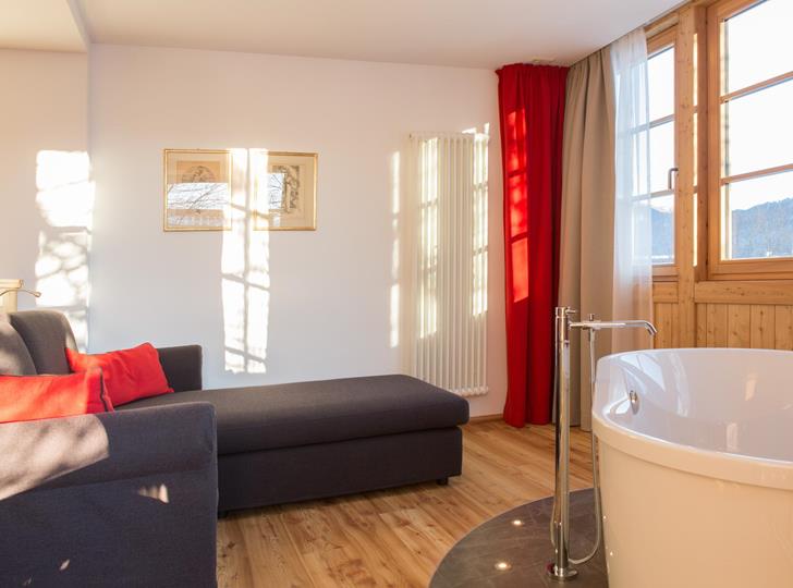 Romantic Suite con vasca da bagno freestanding, angolo soggiorno e ampia vetrata.