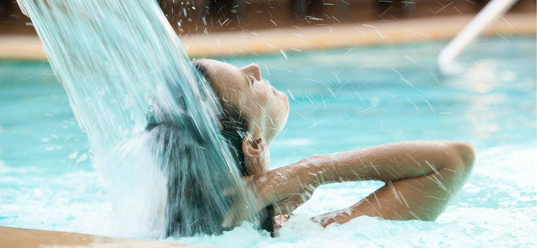 Eine Frau erfrischt sich im Pool.