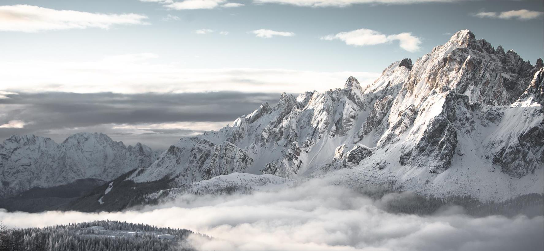 Le Dolomiti innevate con la nebbia in arrivo che si solleva sopra le valli.