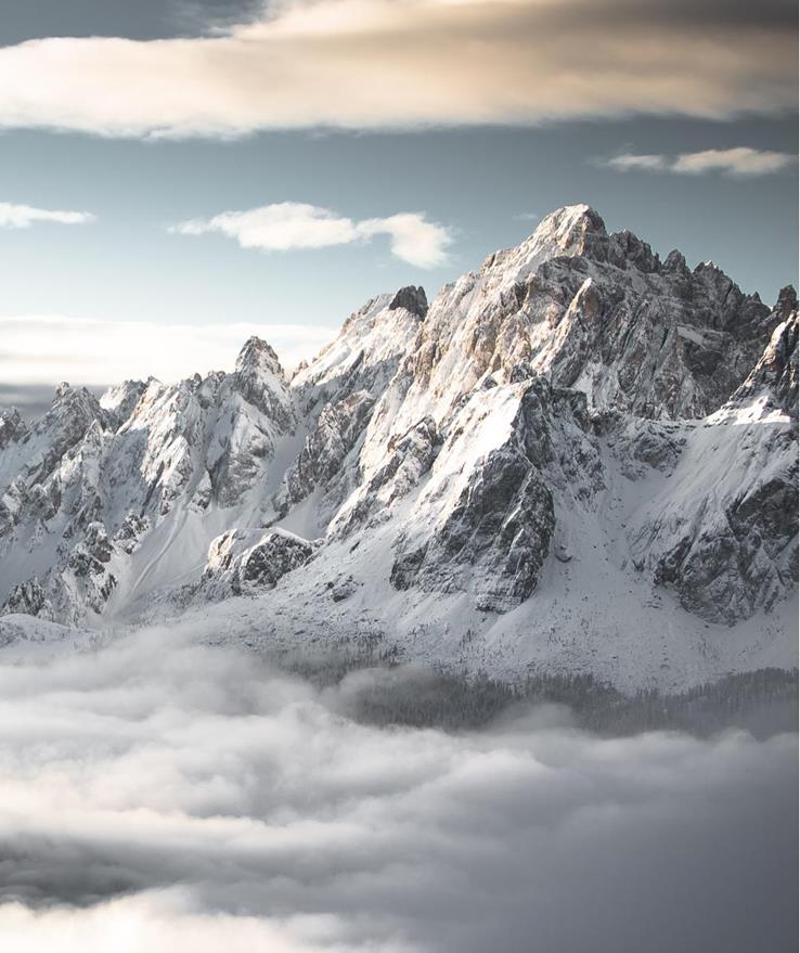 Die verschneiten Dolomiten mit aufziehendem Nebel über den Tälern.