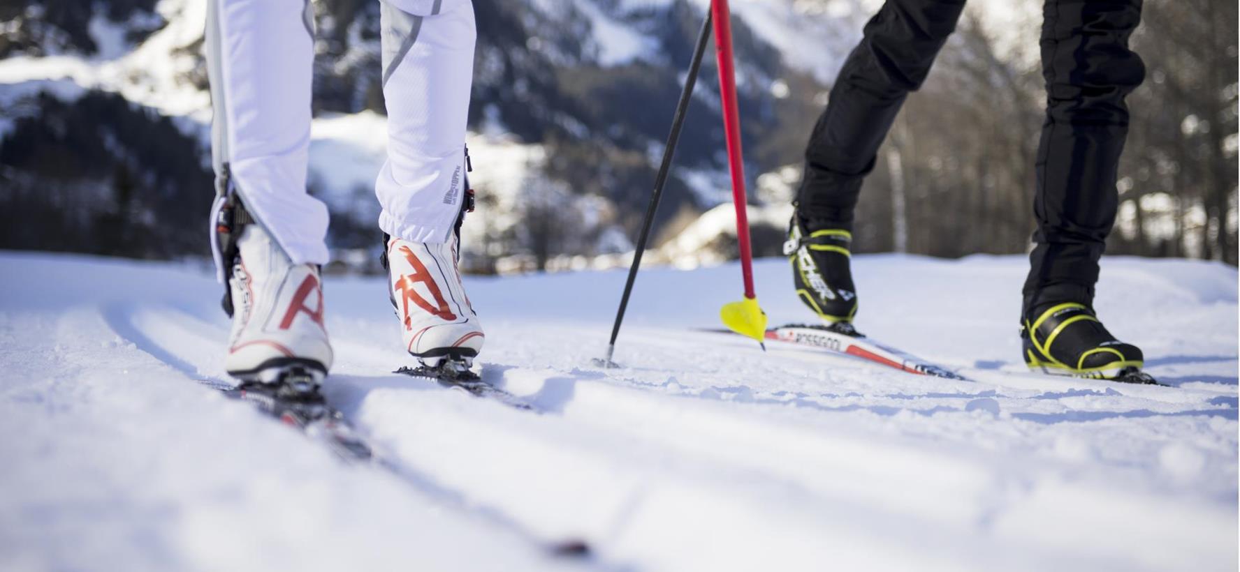 Langläufer auf einer gespurten Loipe in verschneiter Winterlandschaft.
