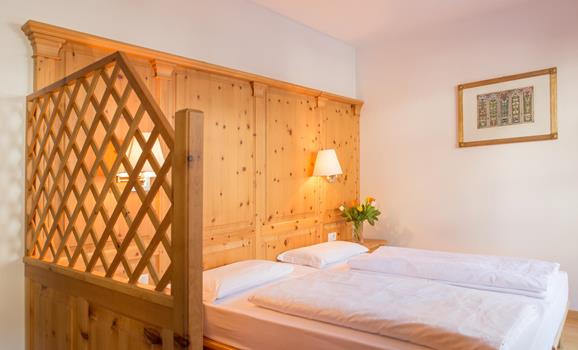 Camera Superior con letto matrimoniale, rivestimento in legno chiaro e parete divisoria in legno.