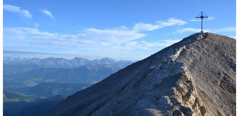 Dürrenstein mit Gipfelkreuz und Blick auf die umliegende Berglandschaft.
