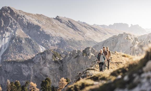 Hiker in an autumn landscape with a striking mountain range in the background.