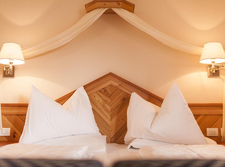 Superior Zimmer mit Doppelbett, Holzvertäfelung und zwei Nachttischlampen.