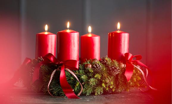 Advent wreath with red candles and bows.