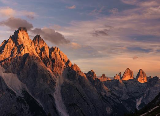 Panoramablick auf die Drei Zinnen in den Dolomiten mit alpiner Landschaft im Abendlicht.
