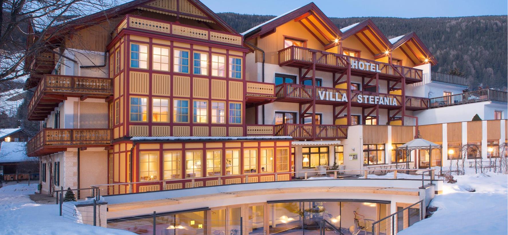 Hotel Villa Stefania in Innichen with a snow-covered garden in front.