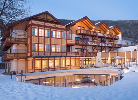 Hotel Villa Stefania in Innichen vor schneebedecktem Garten.