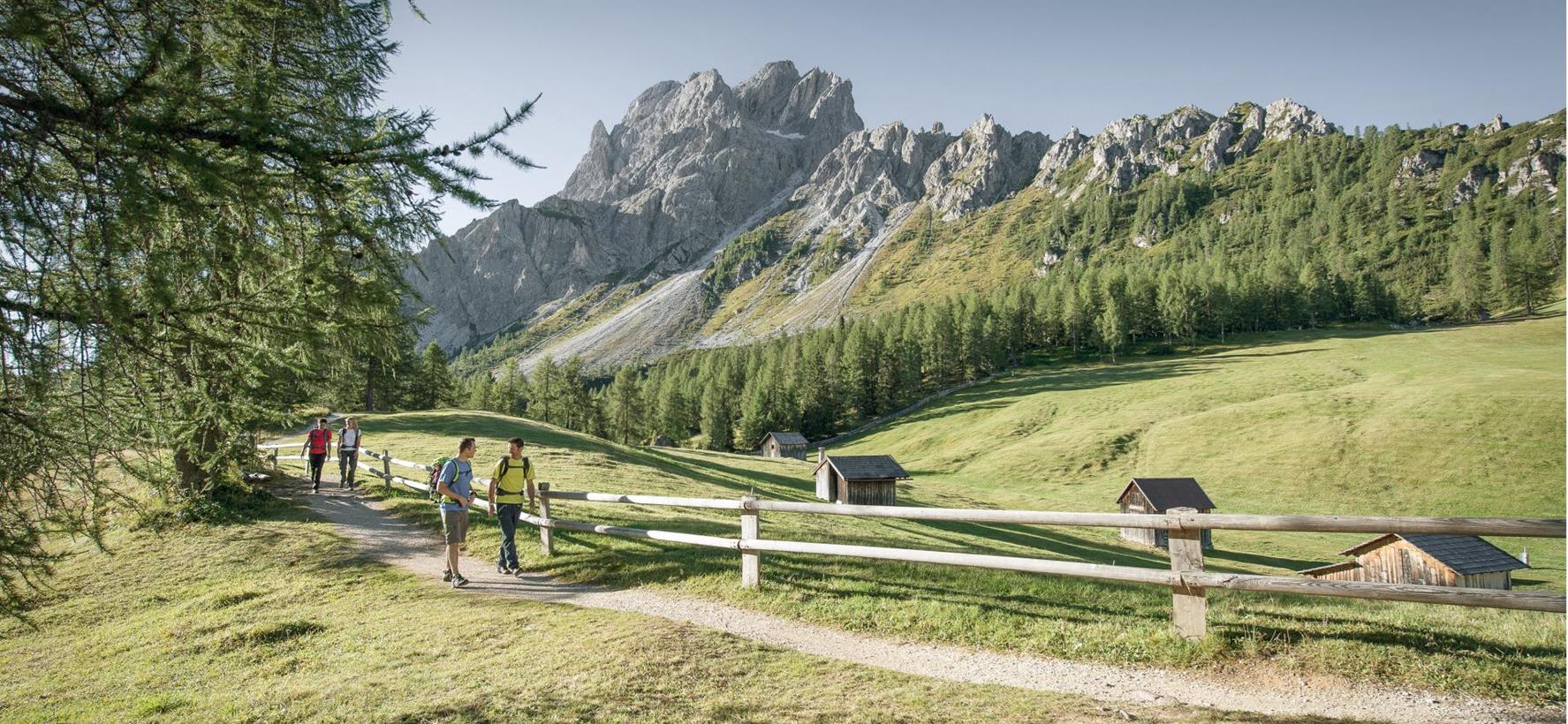 Hiker on a mountain trail with views of the Three Peaks in the Dolomites