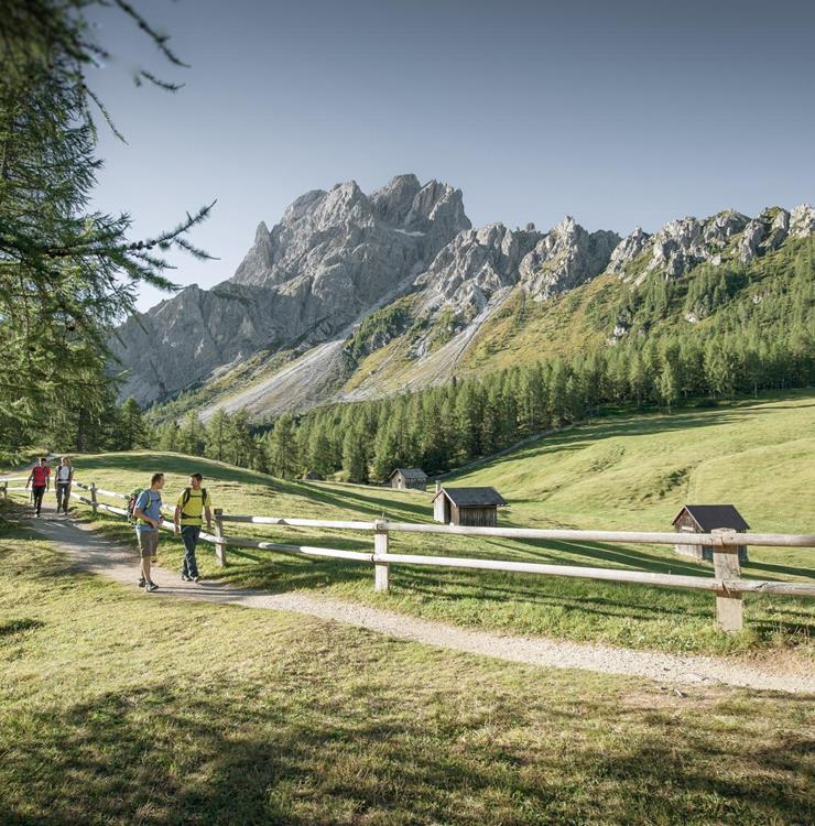 Hiker on a mountain trail with views of the Three Peaks in the Dolomites
