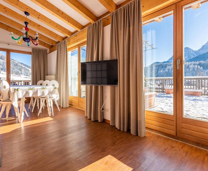 Panorama Suite with wooden flooring, large panoramic windows, cosy seating area and views of the Dolomites.