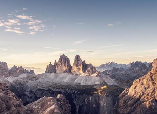 Vista panoramica sulle Tre Cime di Lavaredo nelle Dolomiti con paesaggio alpino e la delicata luce del cielo mattutino.