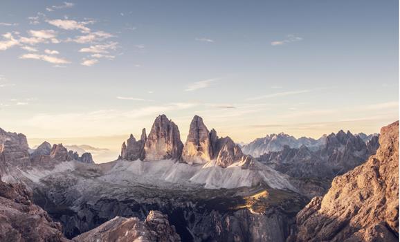 Panoramic view of the Tre Cime di Lavaredo in the Dolomites with an alpine landscape and the soft light of the morning sky.
