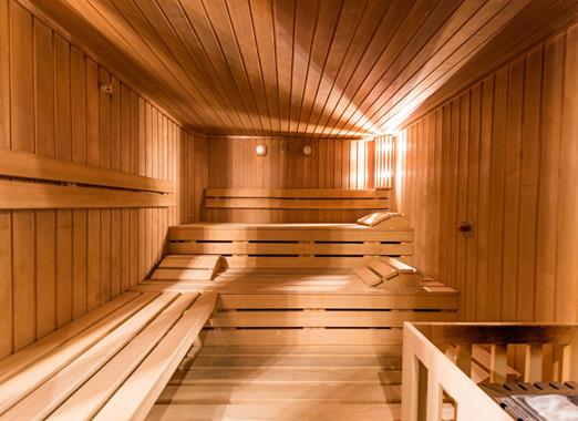 Biosauna moderna con luce calda, panche e un’atmosfera rilassante di benessere.
