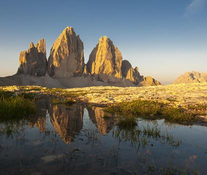 The majestic Tre Cime di Lavaredo in the Dolomites in an alpine landscape in bright sunshine.