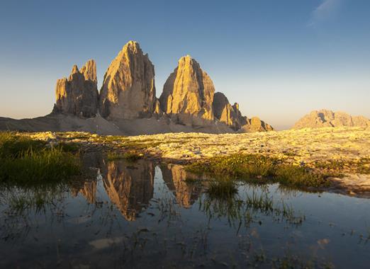 The majestic Tre Cime di Lavaredo in the Dolomites in an alpine landscape in bright sunshine.