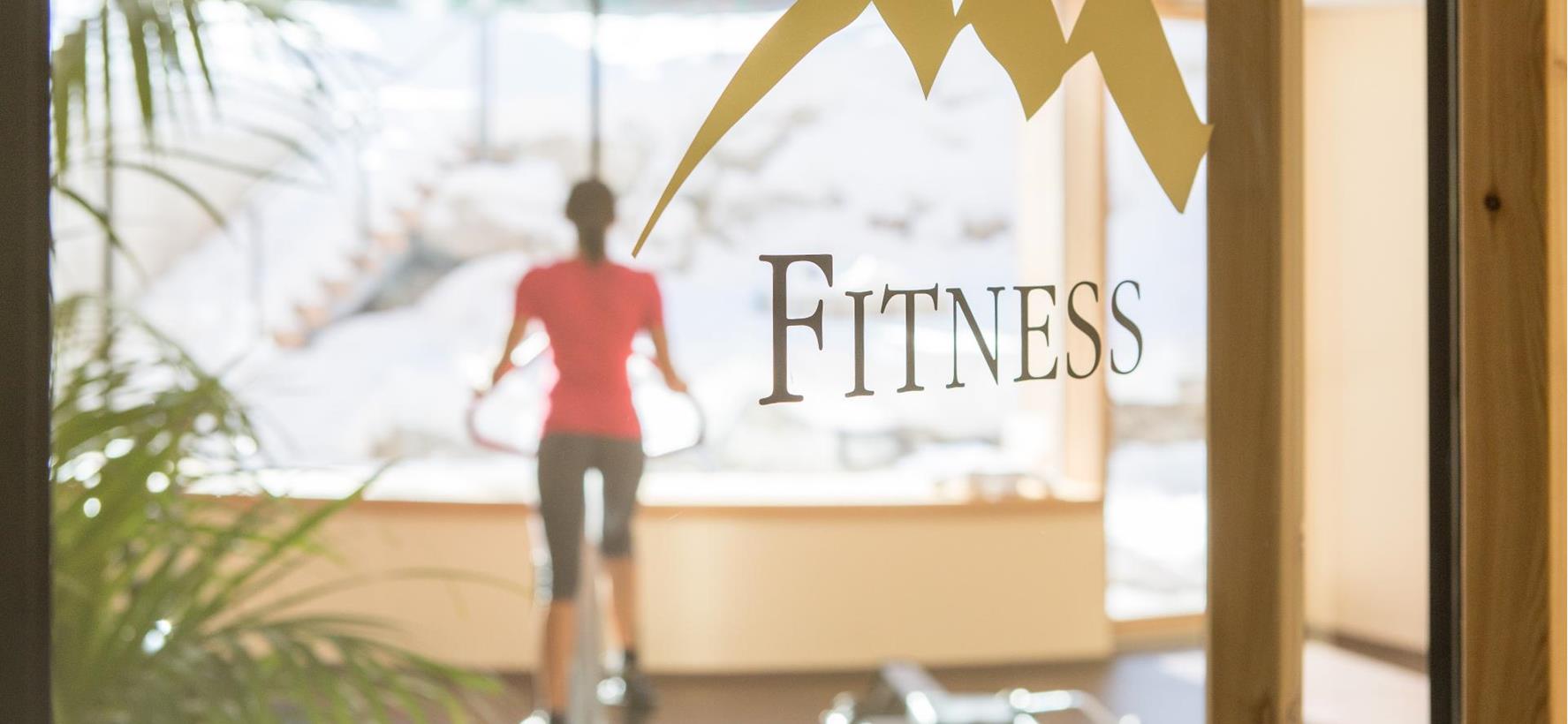Eine Frau auf dem Cross Trainer im Fitnessbereich der Villa Stefania.