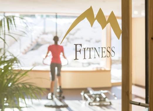 Eine Frau auf dem Cross Trainer im Fitnessbereich der Villa Stefania.