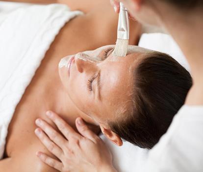 Primo piano del viso di una donna durante un trattamento cosmetico.