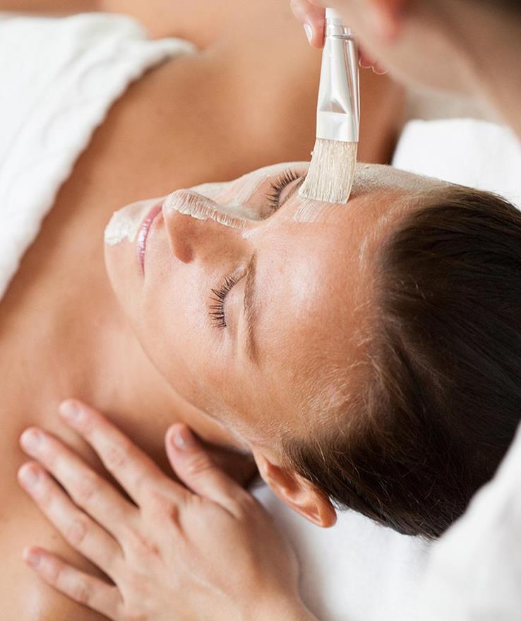 Primo piano del viso di una donna durante un trattamento cosmetico.