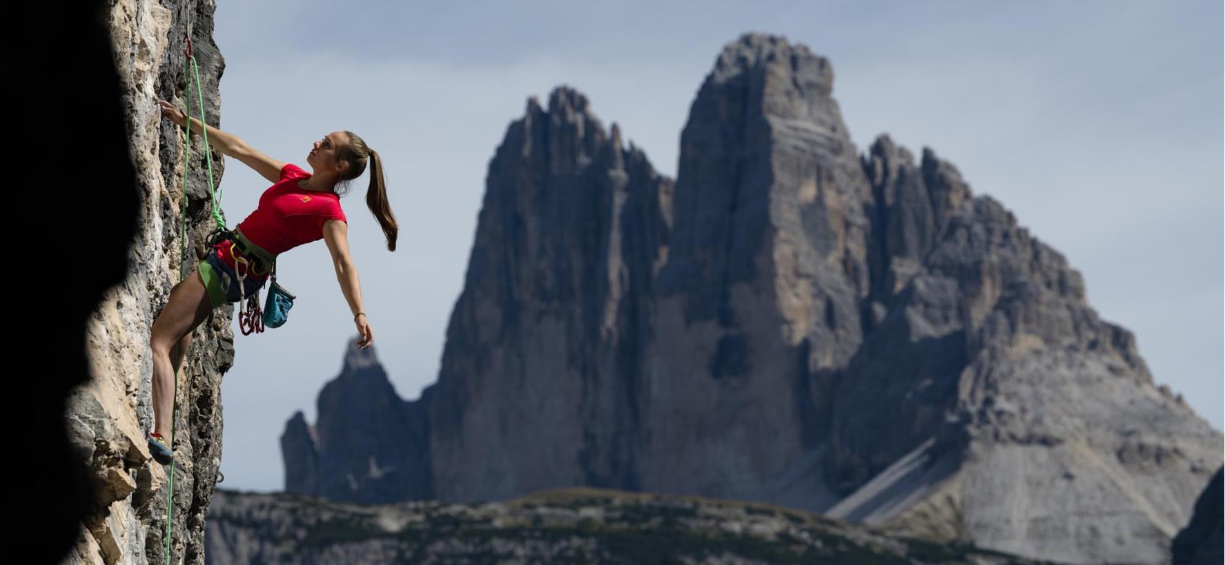 Arrampicatore su una ripida parete rocciosa nelle Dolomiti
