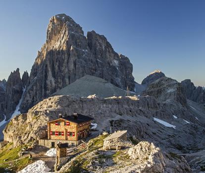 Aerial view of the Büllelejochhütte surrounded by the impressive mountain landscape of the Dolomites.