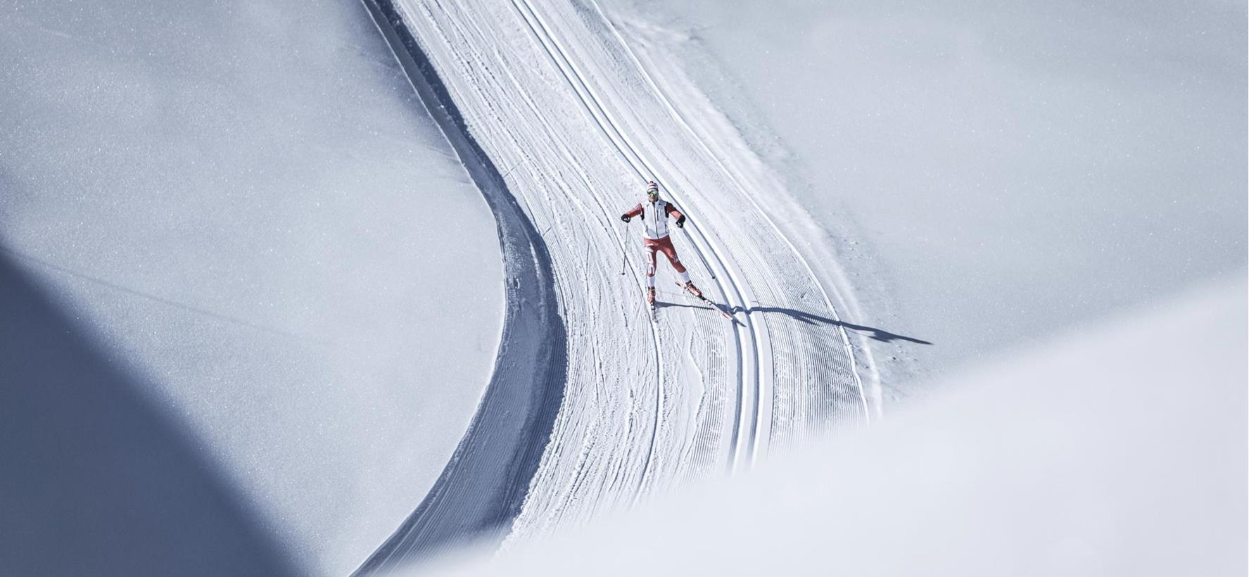 Langläufer auf einer gespurten Loipe in schneebedeckter Winterlandschaft