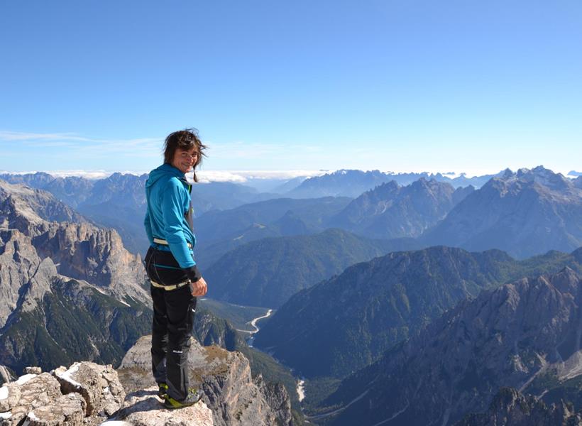 Kletterer auf der Großen Zinne in den Dolomiten mit markanten Felsformationen und alpiner Berglandschaft im Hintergrund.