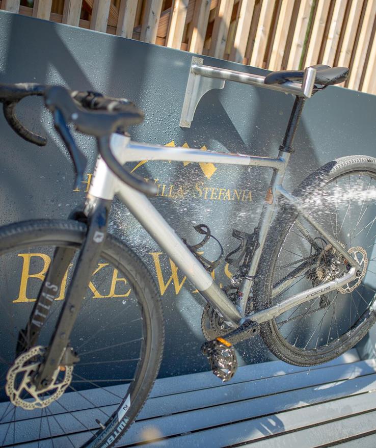 Primo piano di una bicicletta lavata con un tubo dell'acqua.