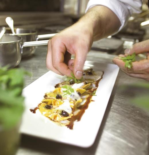 Chef plating a ravioli dish.