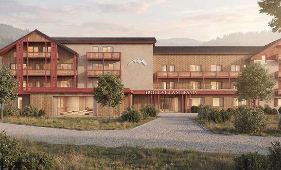 Exterior view of Villa Stefania in San Candido with a wooden façade, balconies, entrance area and landscaped garden.