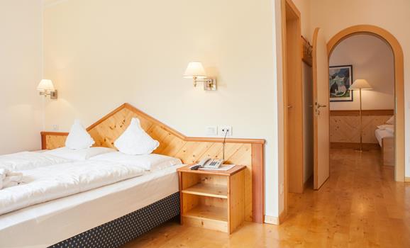 Family Suite with double bed, wooden floor and arched doorway.