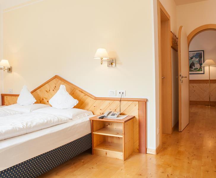 Family Suite mit Doppelbett Holzfußboden und Rundbogen-Durchgang.